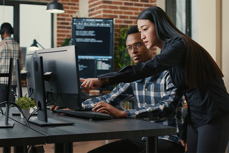 man and woman pointing at the computer